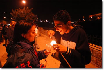 ragazzi che accendono una candela della pace